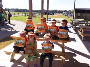 VPK Children from Roots & Wings Preschool in St. Augustine, show off their new fall visors while they hold their free "Spookley" book they received.